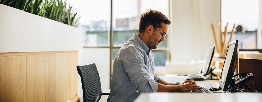 A man focused on working at his desk, representing the meticulous analysis performed by Chambers Advisory Group during a Telecom Expense Audit.